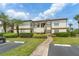 Two story condo building with terracotta roof, green spaces, and lush, tropical landscaping at 3475 Flossmoor Ave # 103, Orlando, FL 32822