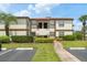 Condominium building exterior with neatly trimmed landscaping and parking at 3475 Flossmoor Ave # 103, Orlando, FL 32822