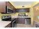 View of the kitchen showcasing stainless steel appliances and a pass through window at 3475 Flossmoor Ave # 103, Orlando, FL 32822