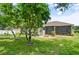 Well maintained backyard with lush green grass, trees and screened in porch at 3696 Peacepipe Ct, Clermont, FL 34711