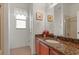 Bathroom vanity with granite countertop, decorative artwork, and shower at 3696 Peacepipe Ct, Clermont, FL 34711