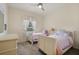 Charming bedroom with twin beds, soft lighting, and a window at 3696 Peacepipe Ct, Clermont, FL 34711