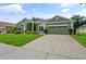 Well-maintained home with lush lawn, mature landscaping, and a brick-paved driveway at 3696 Peacepipe Ct, Clermont, FL 34711