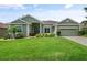 Beautiful single-story home with lush lawn, mature landscaping, and inviting entryway at 3696 Peacepipe Ct, Clermont, FL 34711