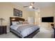 Spacious main bedroom with a ceiling fan, TV, and access to an en-suite bathroom at 3696 Peacepipe Ct, Clermont, FL 34711