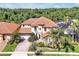 Aerial view of mediterranean style home with red tile roof and lush landscaping at 3844 Bowfin Trl, Kissimmee, FL 34746