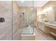 Modern bathroom featuring frameless glass shower, dual sinks, and tiled floors at 3844 Bowfin Trl, Kissimmee, FL 34746