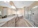 Bright bathroom featuring dual vanities, soaking tub, and frameless glass shower at 3844 Bowfin Trl, Kissimmee, FL 34746