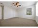 Bright bedroom featuring a ceiling fan, carpeted floors, and a closet with bifold doors at 3844 Bowfin Trl, Kissimmee, FL 34746
