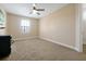 Comfortable bedroom with neutral carpet, a ceiling fan, and ample natural light from the window at 3844 Bowfin Trl, Kissimmee, FL 34746