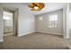 Bedroom with carpet, a ceiling fan, and an open door to a bathroom with a granite vanity at 3844 Bowfin Trl, Kissimmee, FL 34746