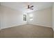 Spacious carpeted bedroom with a ceiling fan and natural light from the two windows at 3844 Bowfin Trl, Kissimmee, FL 34746