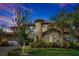 Stately home features a stone turret, tile roof, manicured landscaping, and a side entry two-car garage at 3844 Bowfin Trl, Kissimmee, FL 34746