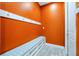 Mud room with orange walls, white storage bench, and hooks for storage at 3844 Bowfin Trl, Kissimmee, FL 34746