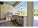 Outdoor kitchen featuring a stainless steel grill, sink, and beverage center at 3844 Bowfin Trl, Kissimmee, FL 34746
