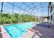 Relaxing screened-in pool and spa surrounded by lush greenery and a clear blue sky at 3844 Bowfin Trl, Kissimmee, FL 34746