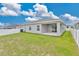 Grassy backyard view with a sliding glass door and covered patio, perfect for outdoor living at 4270 Swan St, Haines City, FL 33844