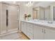 Bright bathroom featuring double sinks with stylish white cabinets and a shower at 4270 Swan St, Haines City, FL 33844
