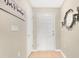 Bright entryway featuring a white front door, light wood flooring, and decorative wall art and sconces at 4270 Swan St, Haines City, FL 33844