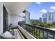 A cozy balcony features a chair, plant and railing with city views at 530 E Central Blvd # 803, Orlando, FL 32801