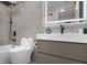Modern bathroom featuring sleek gray tile, minimalist vanity, and tub with shower at 530 E Central Blvd # 803, Orlando, FL 32801