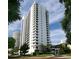 Contemporary white high-rise condominium building with black trim, landscaping, and blue sky at 530 E Central Blvd # 803, Orlando, FL 32801