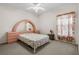 Inviting bedroom boasts a unique headboard, soft carpeting, and a ceiling fan for a cozy retreat at 670 Cotulla Dr, Kissimmee, FL 34758