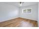 Bright bedroom featuring wood-look floors, a ceiling fan, and a window with tree views at 6700 Tamarind Cir, Orlando, FL 32819