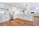 Open kitchen with stainless steel appliances, quartz countertops, white cabinetry, and wood flooring at 6700 Tamarind Cir, Orlando, FL 32819