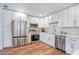 Modern kitchen with stainless steel appliances, white cabinets, quartz countertops, and wood flooring at 6700 Tamarind Cir, Orlando, FL 32819