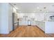 Spacious kitchen featuring stainless steel appliances, quartz counters, an island, and wooden floors at 6700 Tamarind Cir, Orlando, FL 32819
