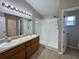 Bathroom features a double vanity, shower with white tiles and a toilet room at 703 Tartan Loop, Lake Wales, FL 33853