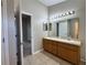 Bright bathroom featuring a double vanity, a large mirror with decorative lighting and tile flooring at 703 Tartan Loop, Lake Wales, FL 33853