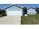 Charming single-story home with a well-maintained lawn, and a white garage door at 703 Tartan Loop, Lake Wales, FL 33853