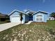 Charming home featuring a well-manicured lawn and blue exterior paint at 703 Tartan Loop, Lake Wales, FL 33853