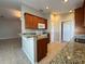 Cozy kitchen featuring granite countertops, wooden cabinetry, and modern appliances at 703 Tartan Loop, Lake Wales, FL 33853