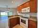 Cozy kitchen with granite countertops, wood cabinets, and stainless steel appliances at 703 Tartan Loop, Lake Wales, FL 33853