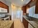 Spacious kitchen boasting granite countertops, stainless steel sink, and wooden cabinets at 703 Tartan Loop, Lake Wales, FL 33853