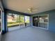 Enclosed patio with painted concrete floors, a ceiling fan, and sliding doors to the backyard at 703 Tartan Loop, Lake Wales, FL 33853