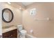 Cozy bathroom with a vanity, toilet, and a round mirror for an intimate setting at 7699 Milano Dr, Orlando, FL 32835