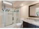 Bathroom featuring a shower with glass doors, granite counters, and decorative tile accents at 7699 Milano Dr, Orlando, FL 32835