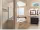 Bright bathroom featuring a walk-in shower, soaking tub, and vanity with modern fixtures at 7699 Milano Dr, Orlando, FL 32835