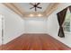 Bright bedroom features tray ceilings, rich hardwood floors, and natural light from large windows at 7699 Milano Dr, Orlando, FL 32835