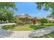 Beautiful home with lush landscaping, mature trees, and well-kept grounds on a sunny day at 7699 Milano Dr, Orlando, FL 32835