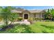 Inviting front yard showcasing lush green grass, a tiled roof, and manicured shrubs and plants at 7699 Milano Dr, Orlando, FL 32835