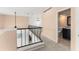Upstairs hallway featuring carpet, iron railing, and a bathroom at 7699 Milano Dr, Orlando, FL 32835