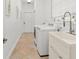 Convenient laundry room featuring a utility sink, washer, dryer, and tile flooring at 7699 Milano Dr, Orlando, FL 32835