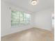 Bright, naturally lit living room featuring neutral tile floors and a large window at 7699 Milano Dr, Orlando, FL 32835