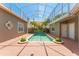 Tranquil screened-in pool surrounded by lush landscaping and decorative plantings at 7699 Milano Dr, Orlando, FL 32835