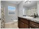 Well-lit bathroom features granite counters, wood cabinets and shower with patterned curtain at 812 Deep Wood Ct, Fruitland Park, FL 34731